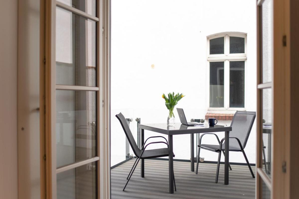 ein Tisch mit Stühlen und ein Laptop auf einem Balkon in der Unterkunft Carl.22 City Appartements in Eisenach + 7 Fotos