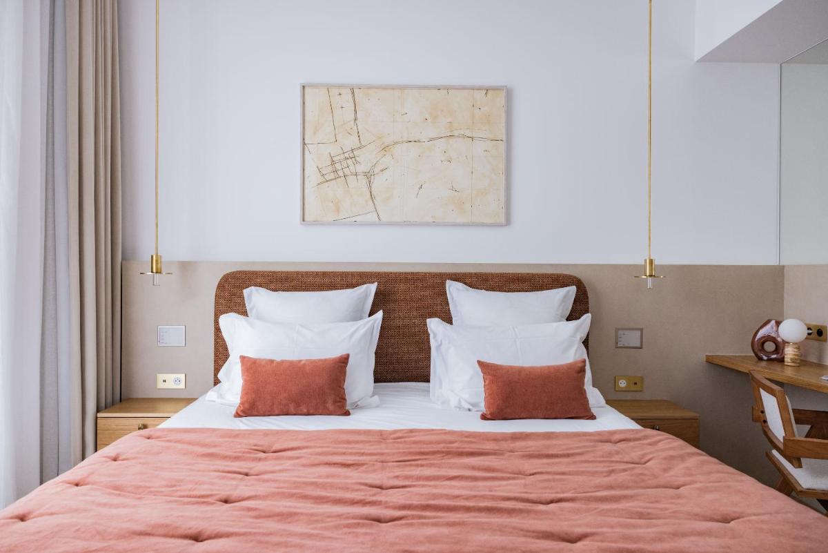 une chambre avec un grand lit aux oreillers orange et blancs dans l'établissement 1.75 Paris La Source, à Paris