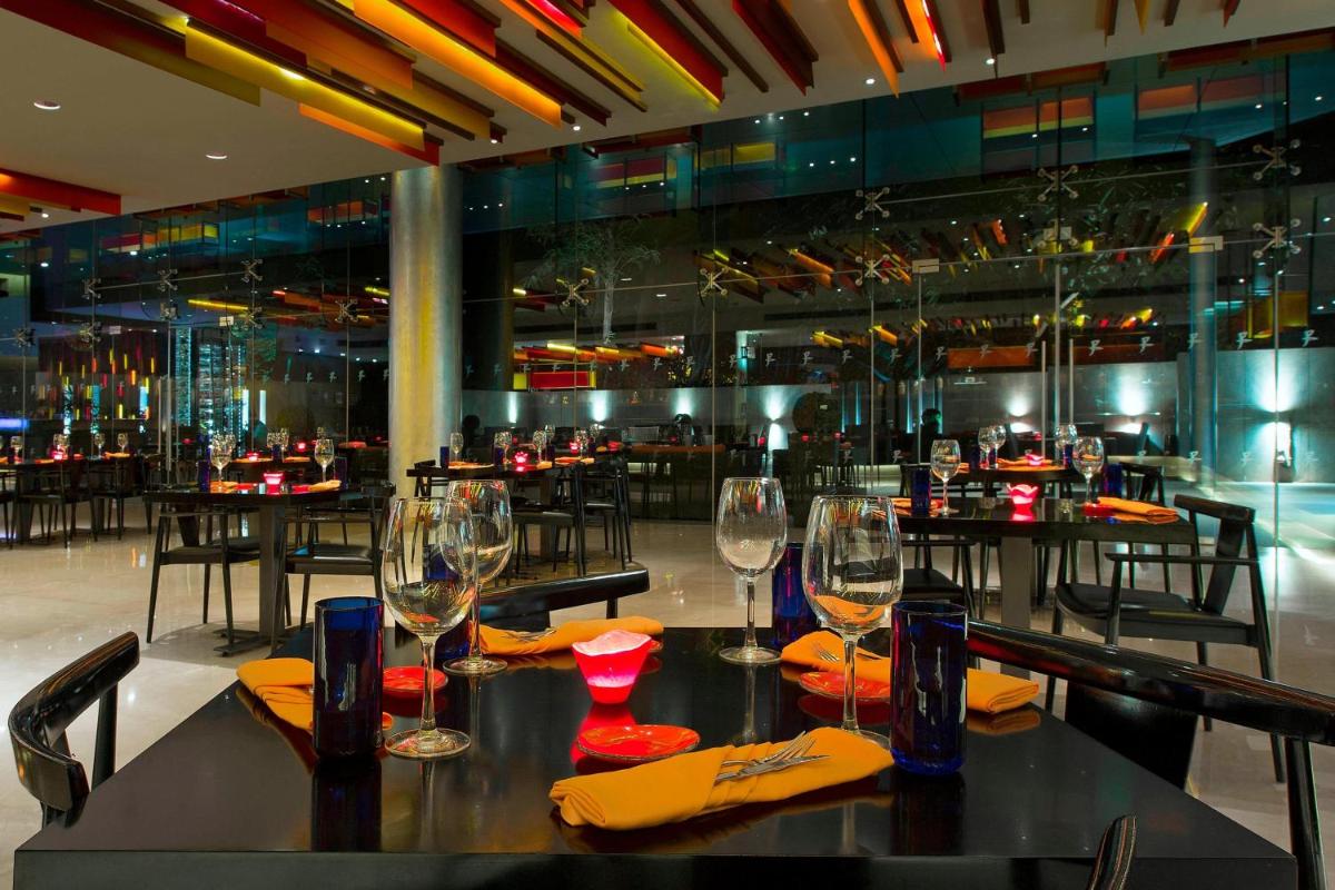 a table with wine glasses on it in a restaurant at The Westin Mumbai Garden City in Mumbai