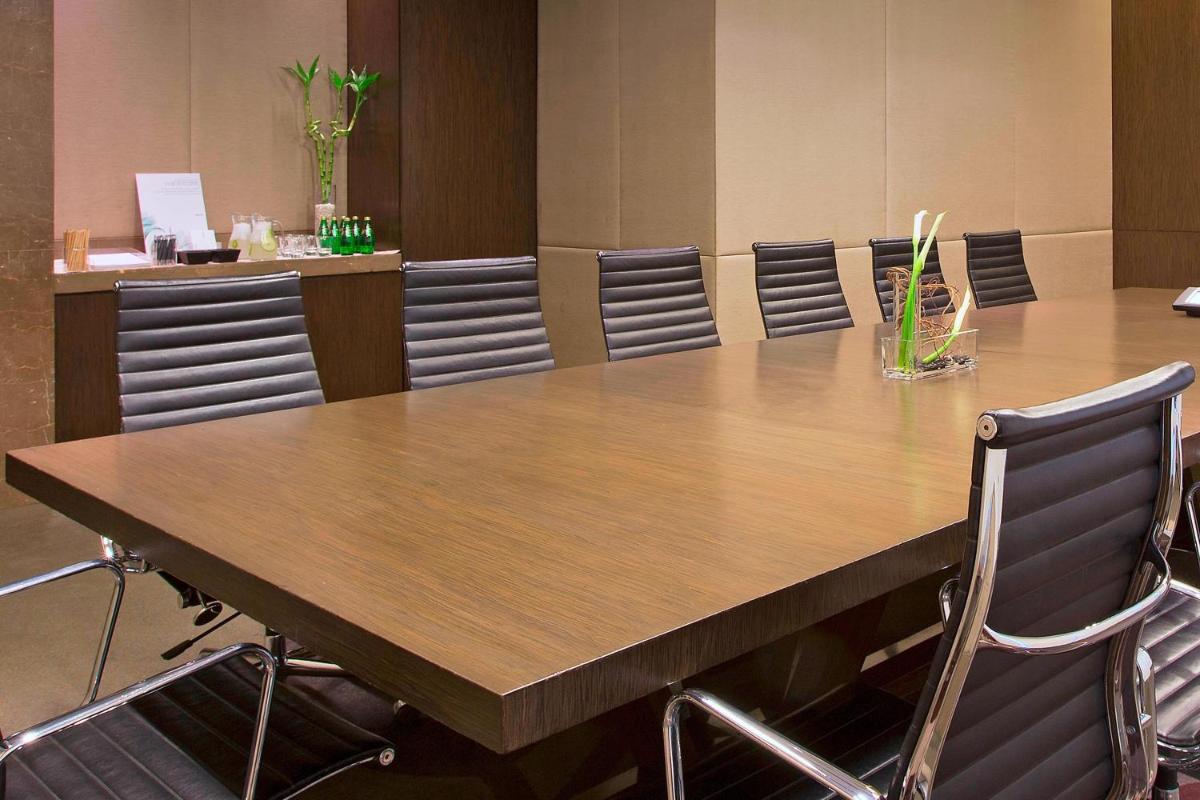 a conference room with a large wooden table and chairs at The Westin Mumbai Garden City in Mumbai