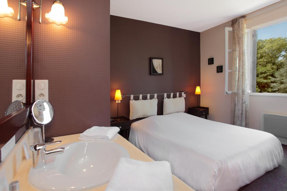 une chambre d'hôtel avec un lit et un lavabo dans l'établissement Logis Deshors-Foujanet, à Chamboulive 52 autres photos