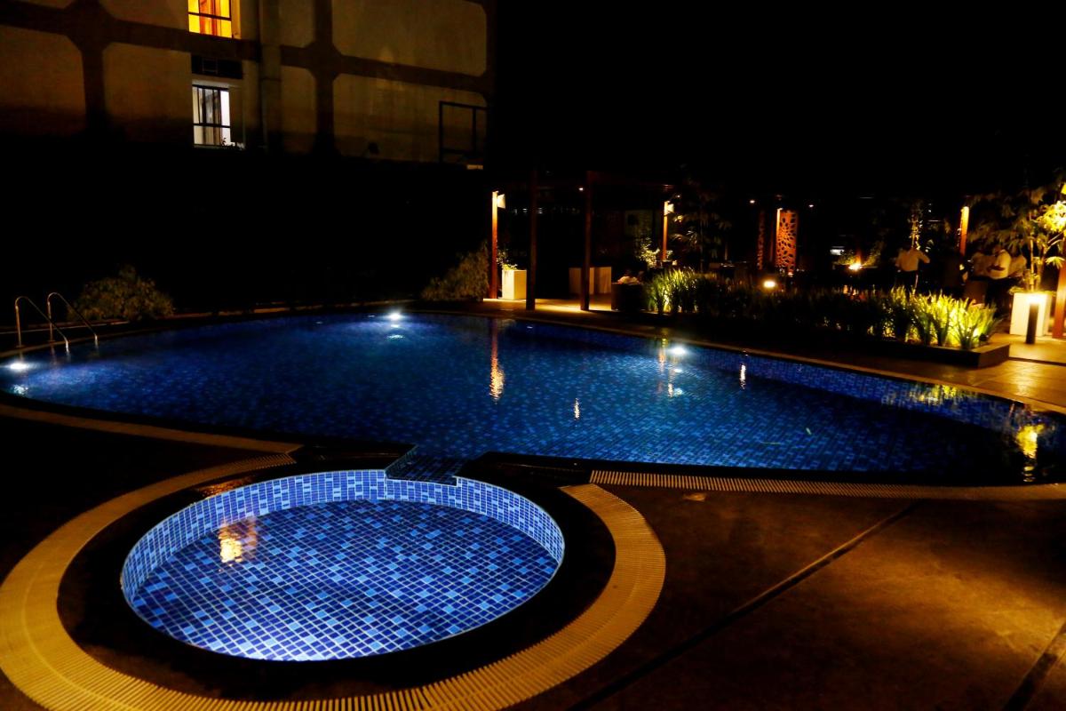 a swimming pool at night with lights on it at The Raviz Calicut in Kozhikode