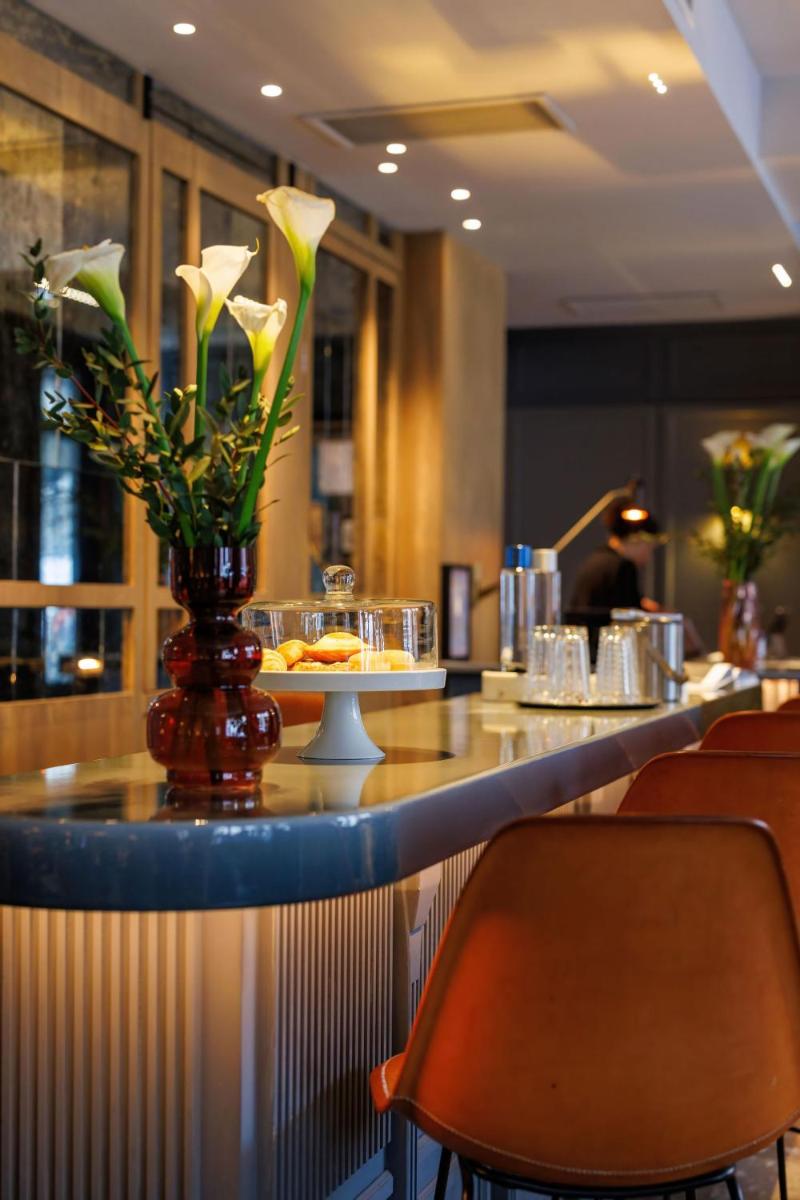 un bar dans un restaurant avec un vase de fleurs dans l'établissement Maison ELLE Paris, à Paris