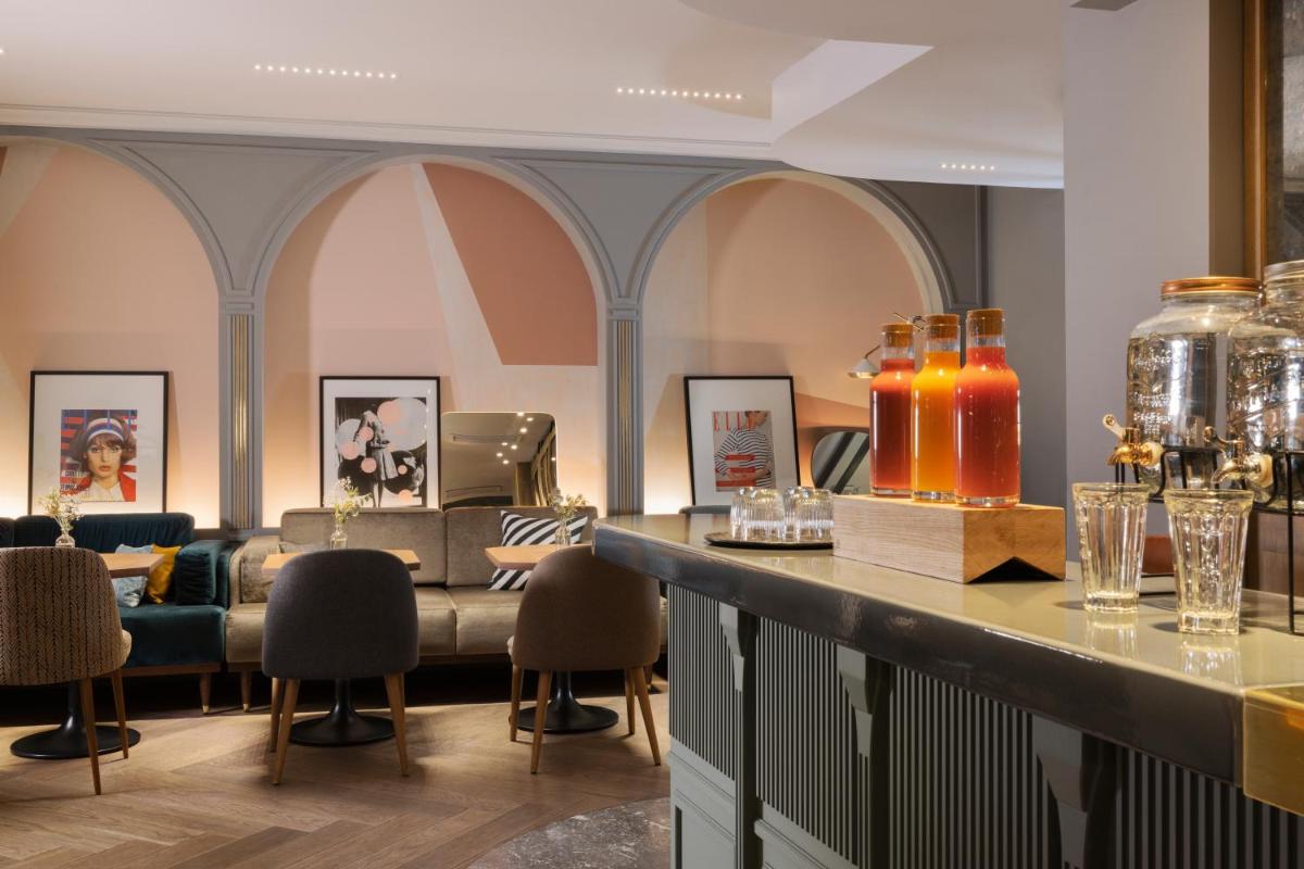un hall d'entrée avec un bar avec un canapé et des chaises dans l'établissement Maison ELLE Paris, à Paris