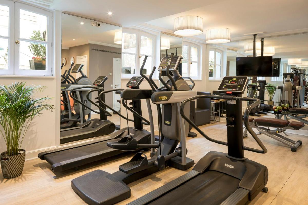 une salle de sport avec plein de tapis de course et de vélos elliptiques dans l'établissement Castille Paris – Starhotels Collezione, à Paris