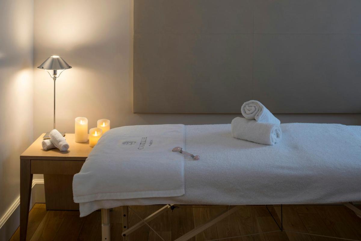 un lit avec des serviettes et une table avec une lampe dans l'établissement Castille Paris – Starhotels Collezione, à Paris 65 autres photos