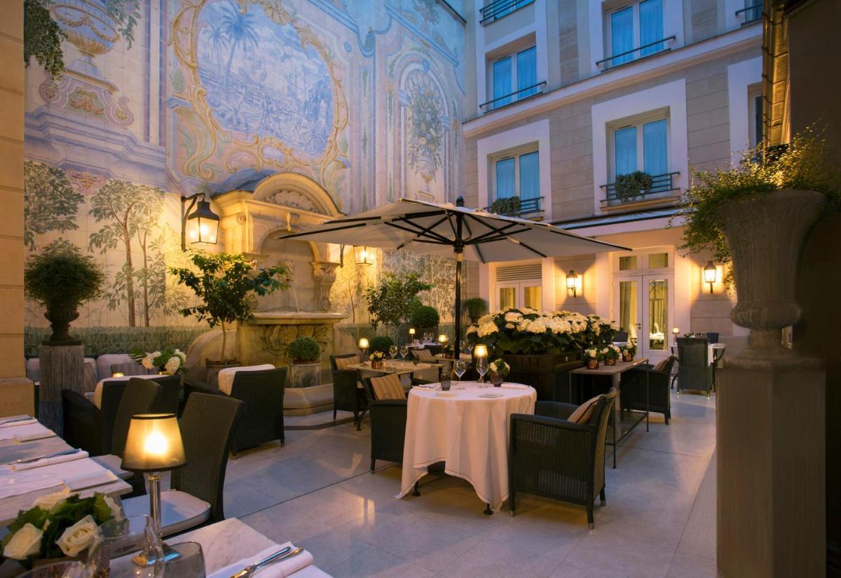 un restaurant avec des tables et des chaises dans un bâtiment dans l'établissement Castille Paris – Starhotels Collezione, à Paris