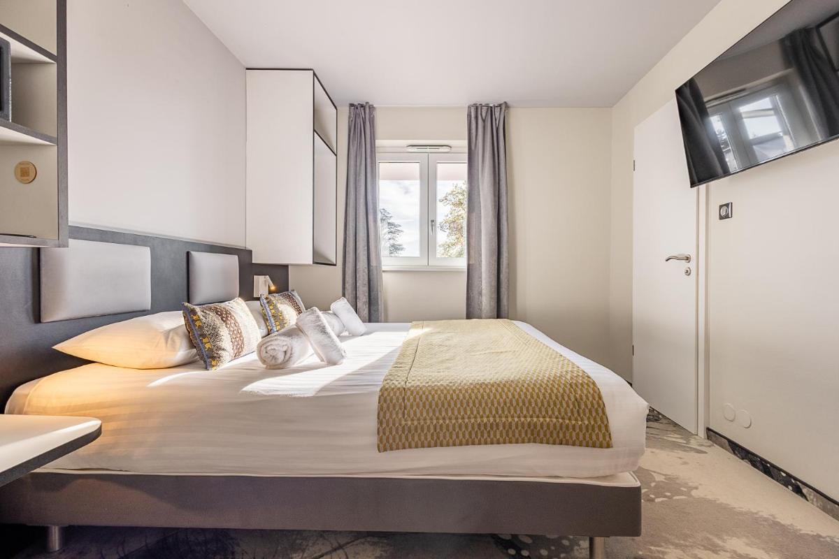 Un ou plusieurs lits dans un hébergement de l'établissement Brit Hotel, Spa & Restaurant - Colmar Est