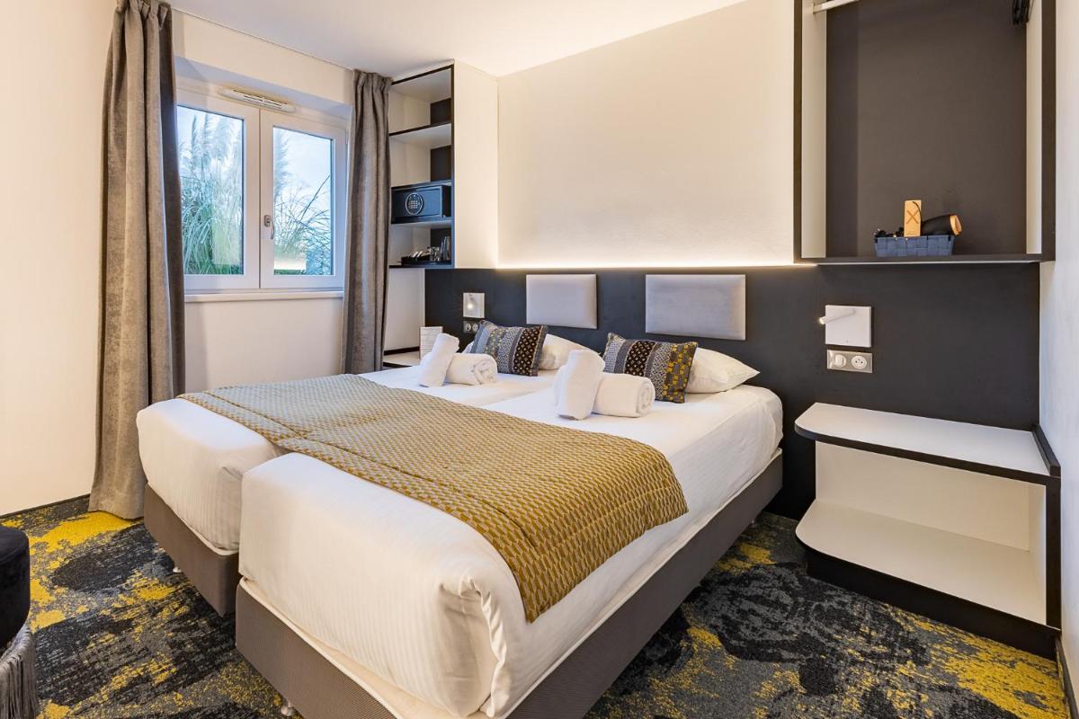 Un ou plusieurs lits dans un hébergement de l'établissement Brit Hotel, Spa & Restaurant - Colmar Est