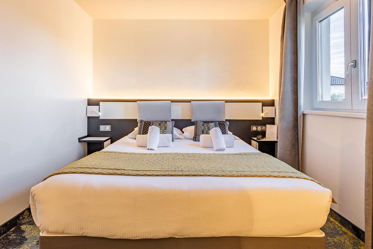 Un ou plusieurs lits dans un hébergement de l'établissement Brit Hotel, Spa & Restaurant - Colmar Est