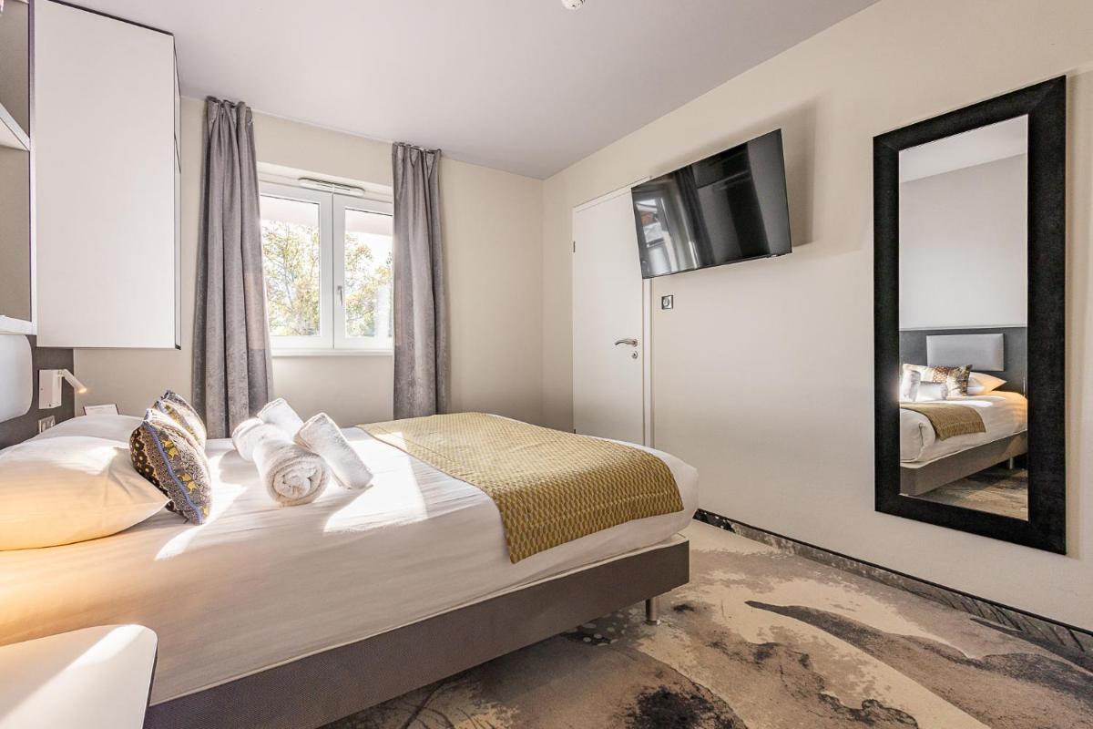 Un ou plusieurs lits dans un hébergement de l'établissement Brit Hotel, Spa & Restaurant - Colmar Est