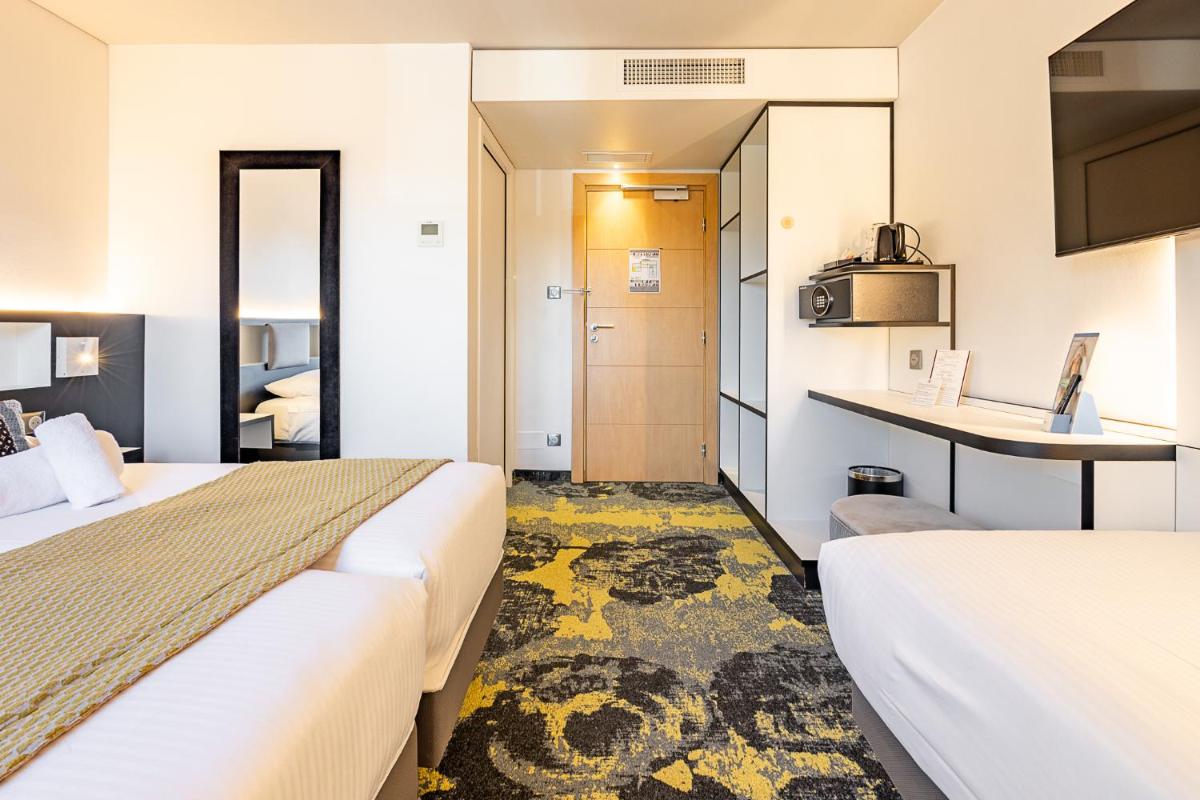 Un ou plusieurs lits dans un hébergement de l'établissement Brit Hotel, Spa & Restaurant - Colmar Est