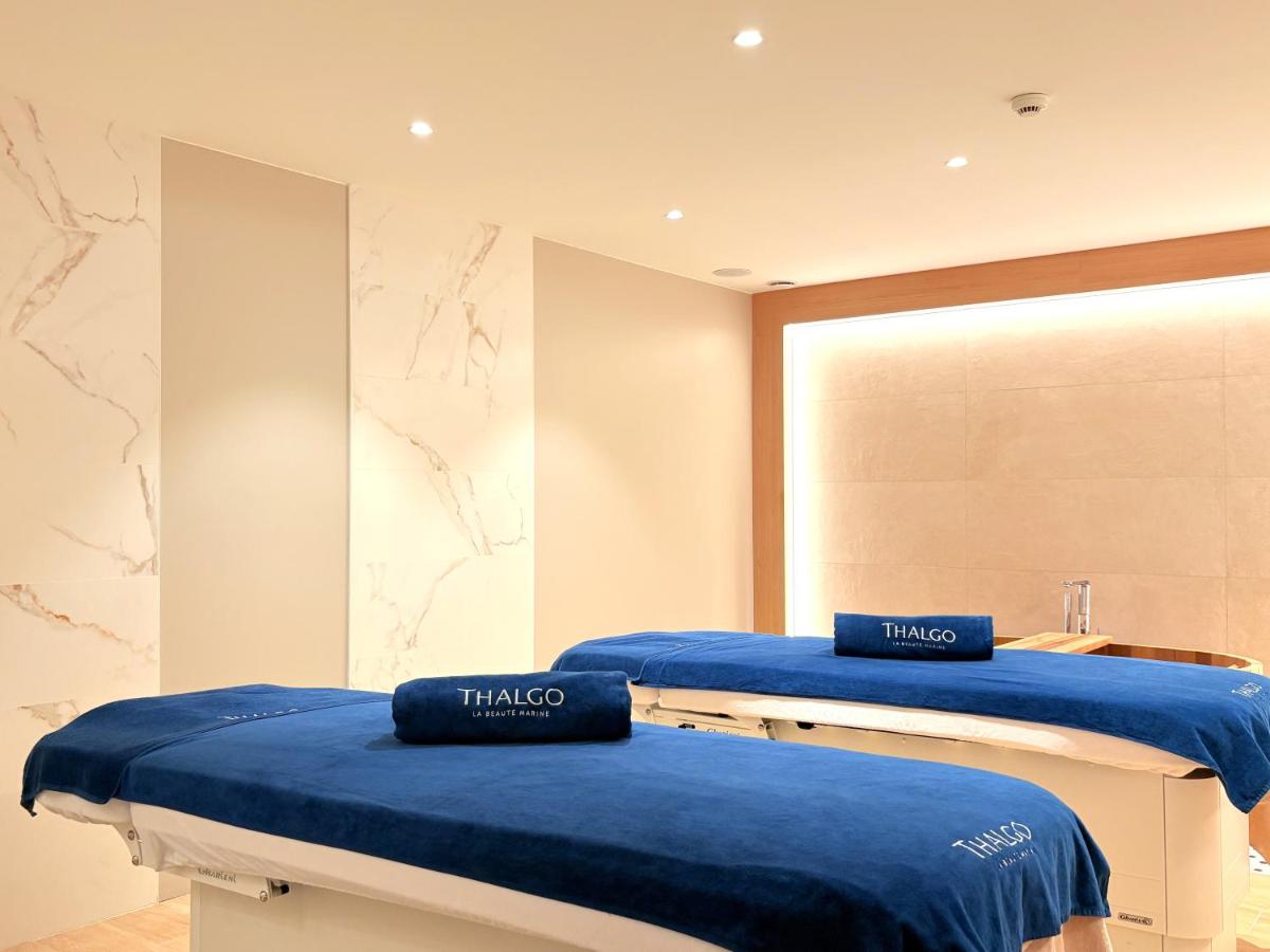 deux lits bleus dans une chambre avec un miroir dans l'établissement Brit Hotel Piscine & Spa - Fougères, à Lécousse 59 autres photos