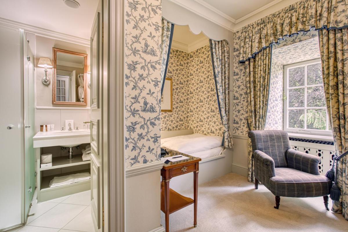 ein Badezimmer mit Waschbecken, Bett und Fenster in der Unterkunft Wald & Schlosshotel Friedrichsruhe in Friedrichsruhe