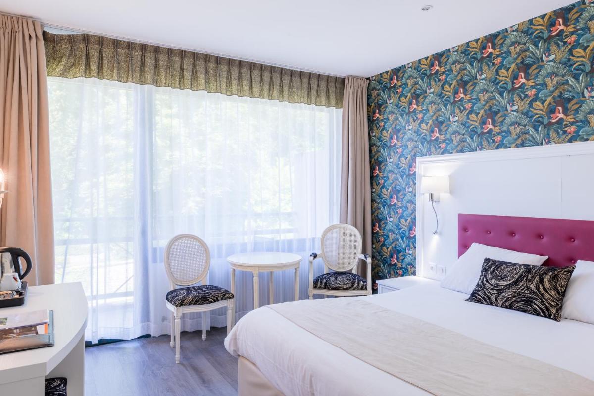 Un ou plusieurs lits dans un hébergement de l'établissement Le Moulin Du Landion Hôtel et Spa