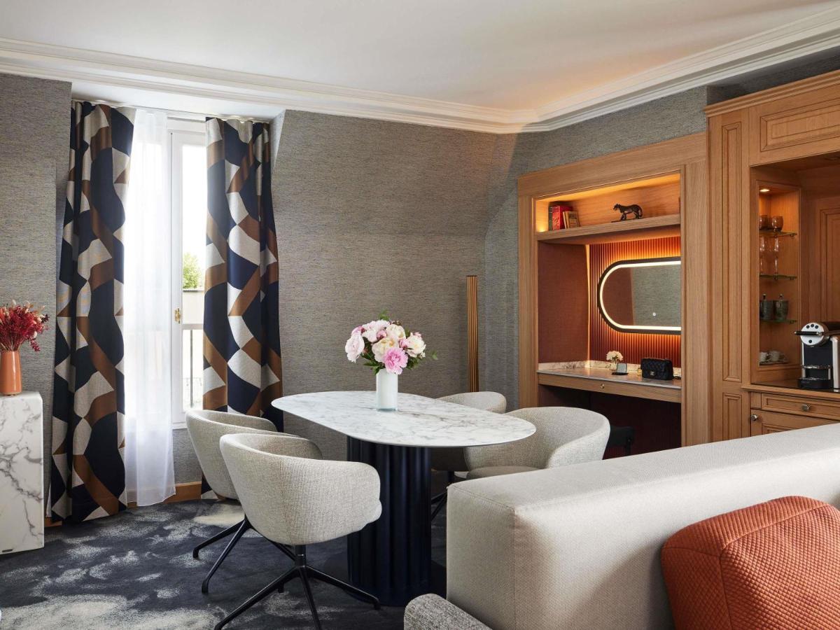 un salon avec une table et des chaises dans l'établissement Sofitel Paris Baltimore Tour Eiffel, à Paris