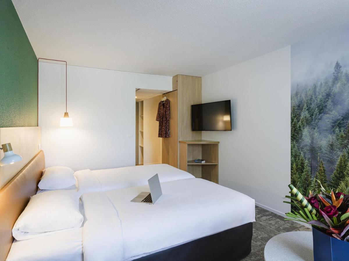une chambre d'hôtel avec un lit blanc et une télévision dans l'établissement ibis Styles Aix les Bains Domaine de Marlioz, à Aix-les-Bains 152 autres photos