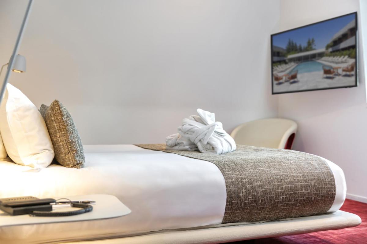 Un ou plusieurs lits dans un hébergement de l'établissement Hôtel Spa Restaurant Villa Castellane