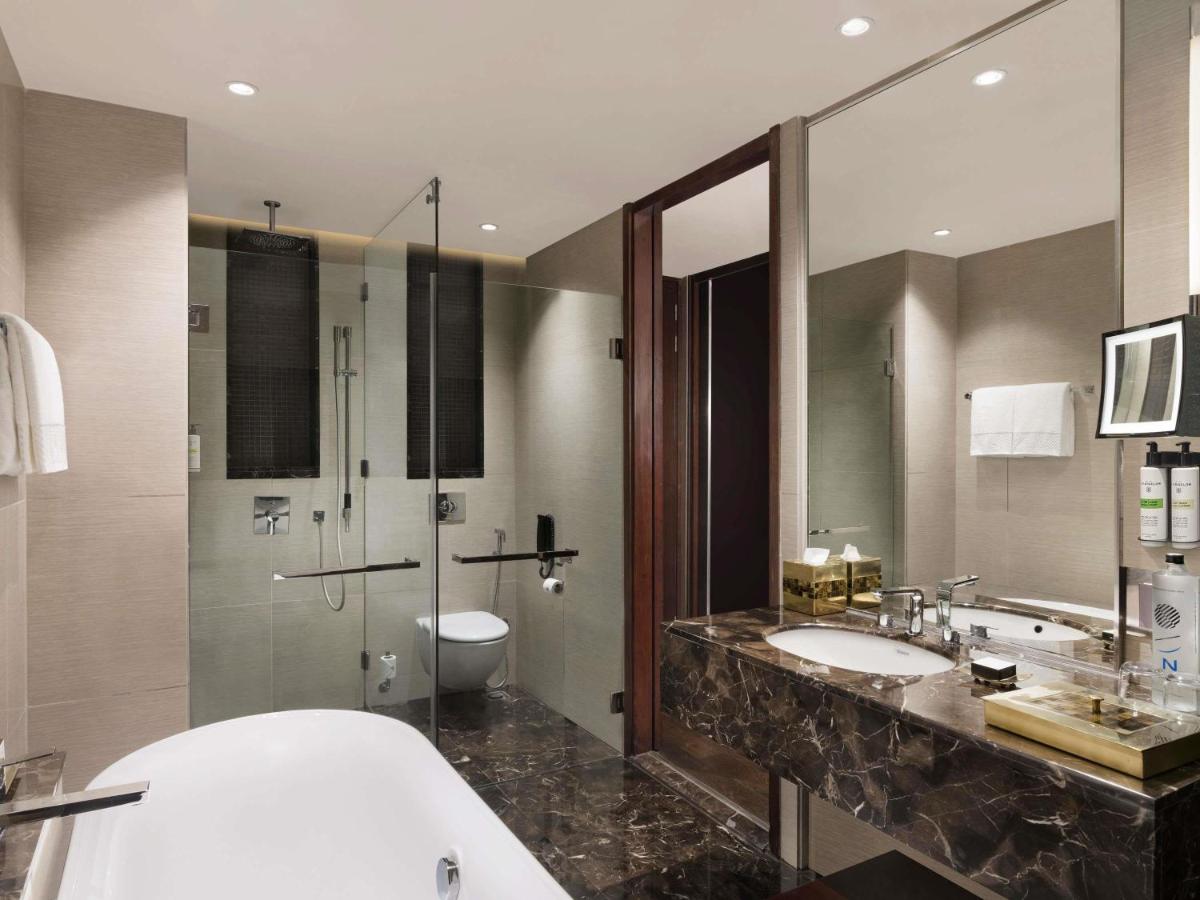 a bathroom with two sinks and a toilet and a shower at Pullman New Delhi Aerocity in New Delhi