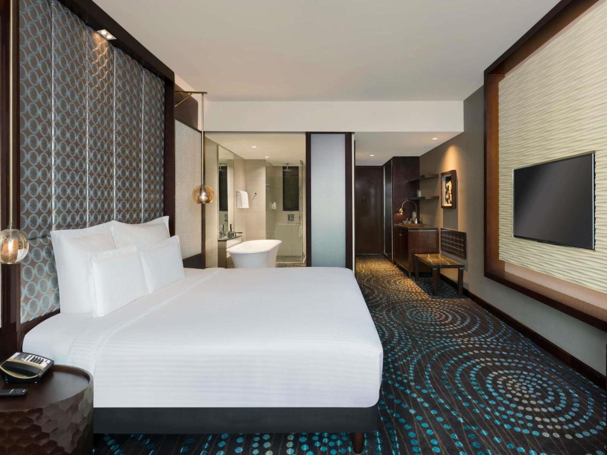 a hotel room with a large bed and a television at Pullman New Delhi Aerocity in New Delhi