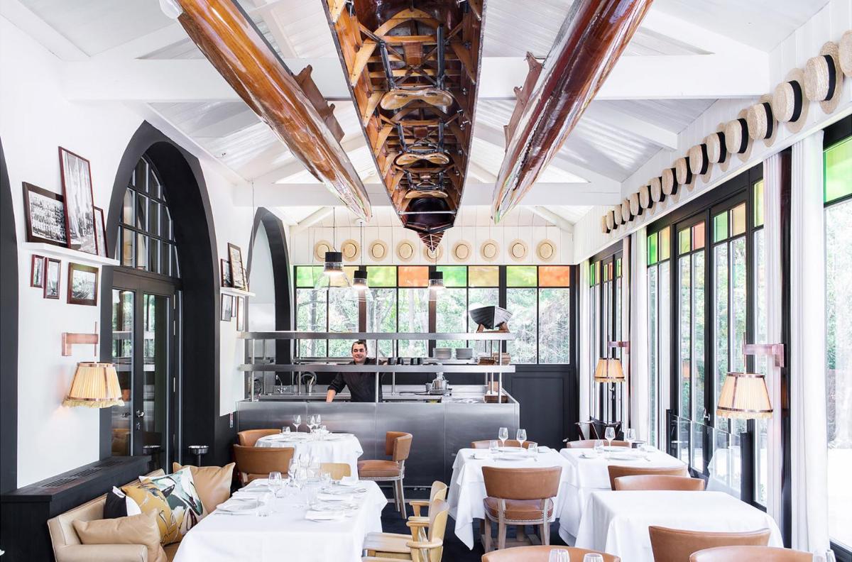 un restaurant avec des tables et des chaises blanches et des fenêtres dans l'établissement Ha(a)ïtza, à Pyla-sur-Mer 21 autres photos