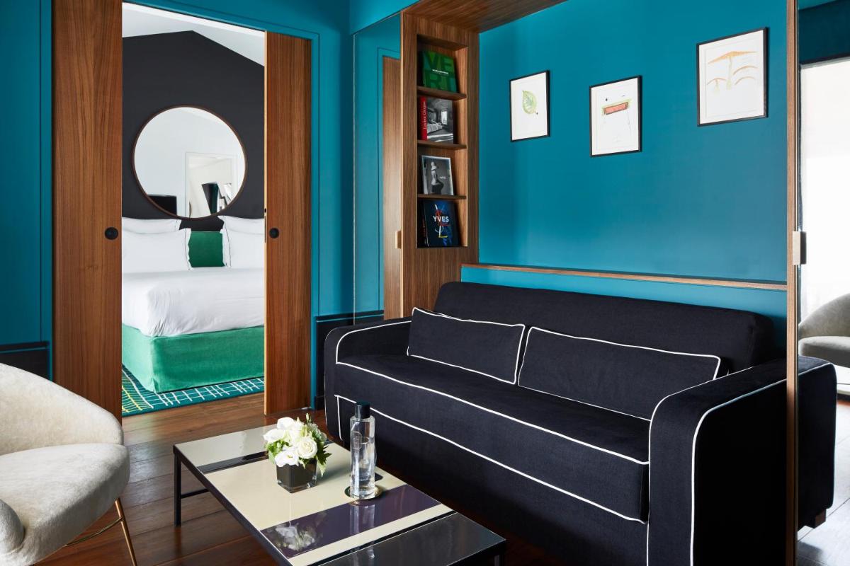 un salon avec un canapé et un mur bleu dans l'établissement Le Roch Hotel & Spa, à Paris