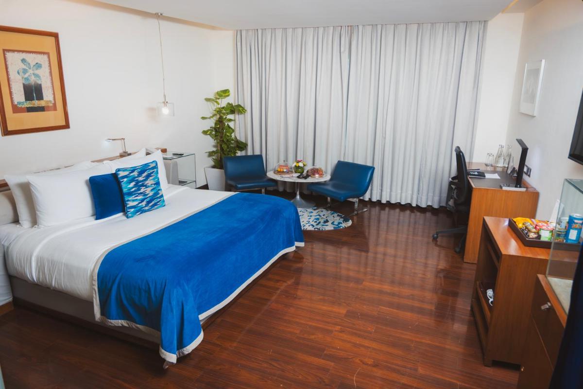 a hotel room with a bed and a table and chairs at The Park New Delhi in New Delhi