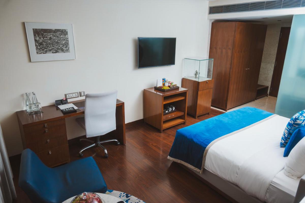 a hotel room with a bed and a desk and a television at The Park New Delhi in New Delhi