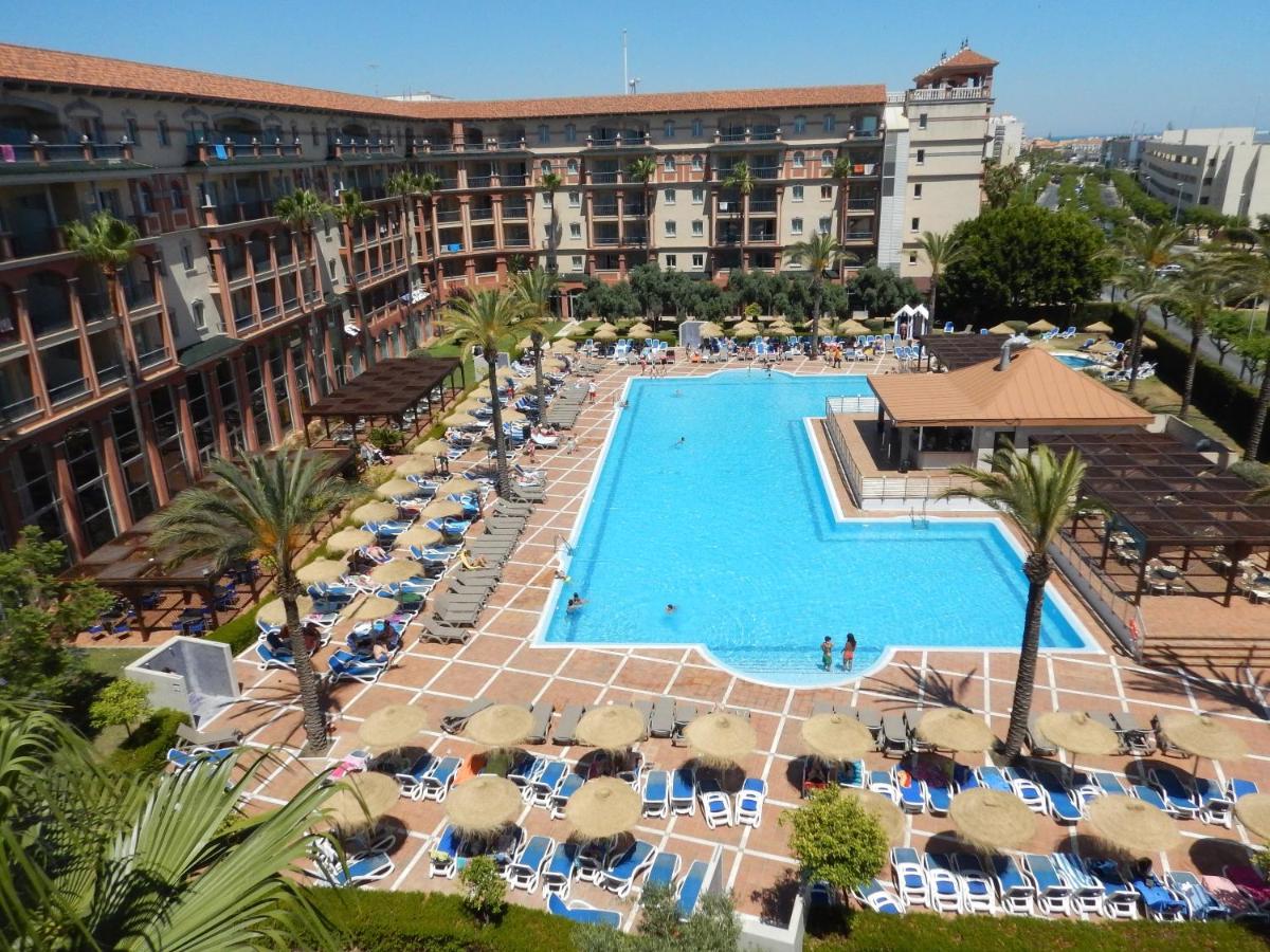una vista aérea de una piscina del hotel con sillas y sombrillas en Ohtels Islantilla, en Islantilla