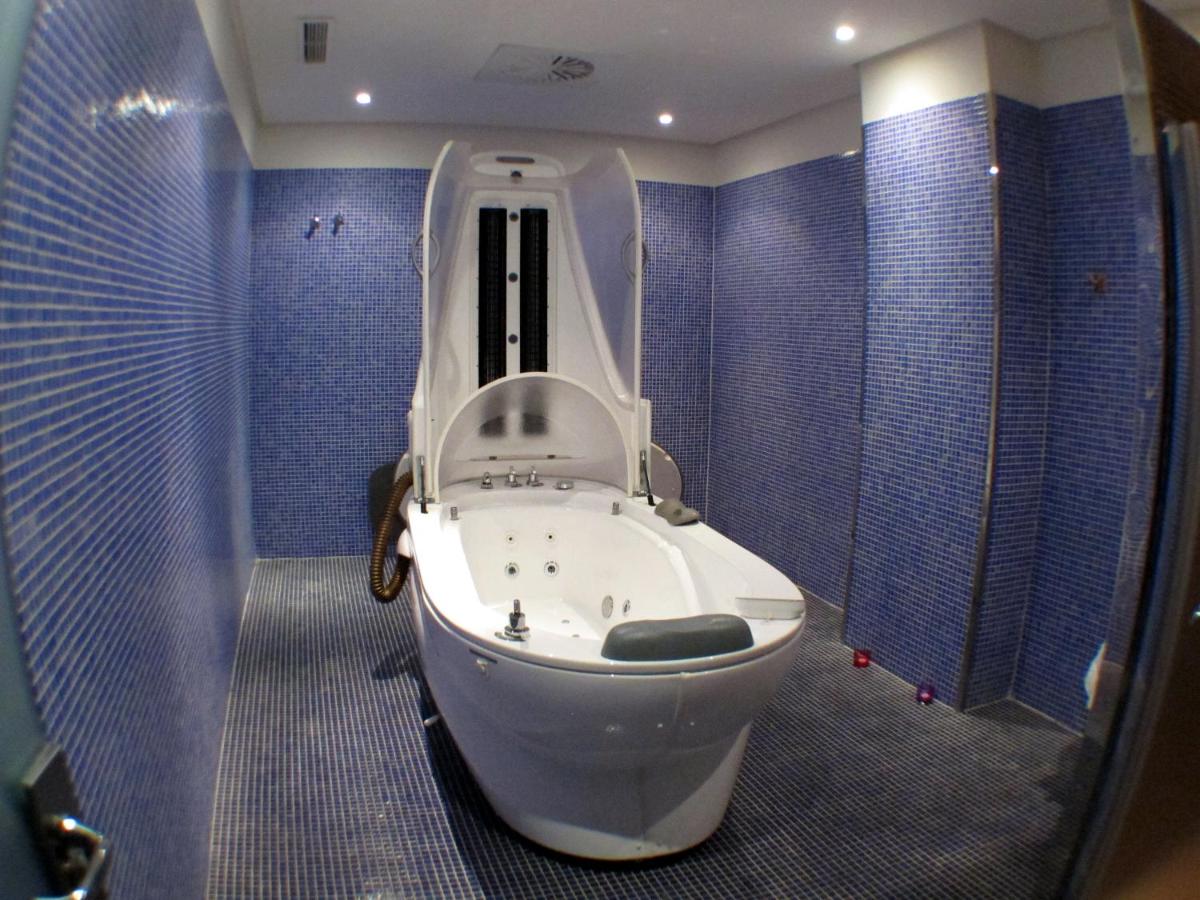 baño con aseo blanco en una habitación azul en Ohtels Islantilla, en Islantilla