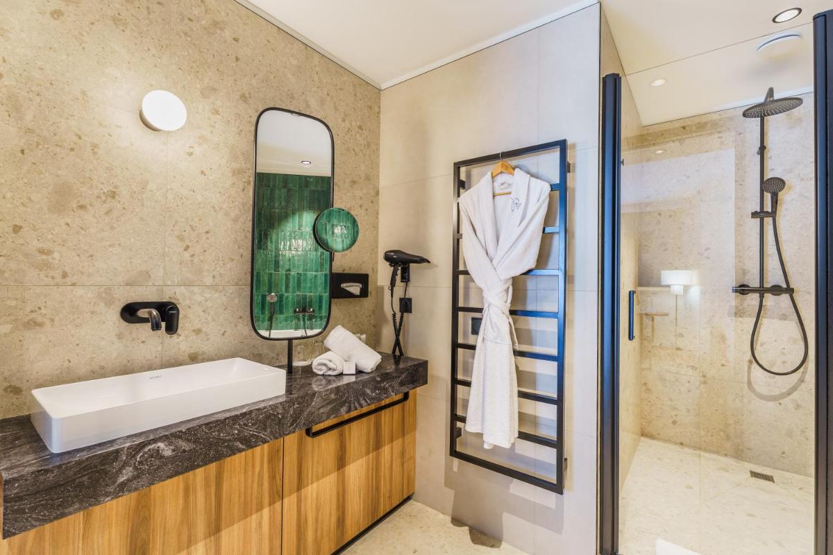 une salle de bain avec lavabo et douche dans l'établissement Le Richebourg Hôtel, Restaurant & Spa, à Vosne-Romanée