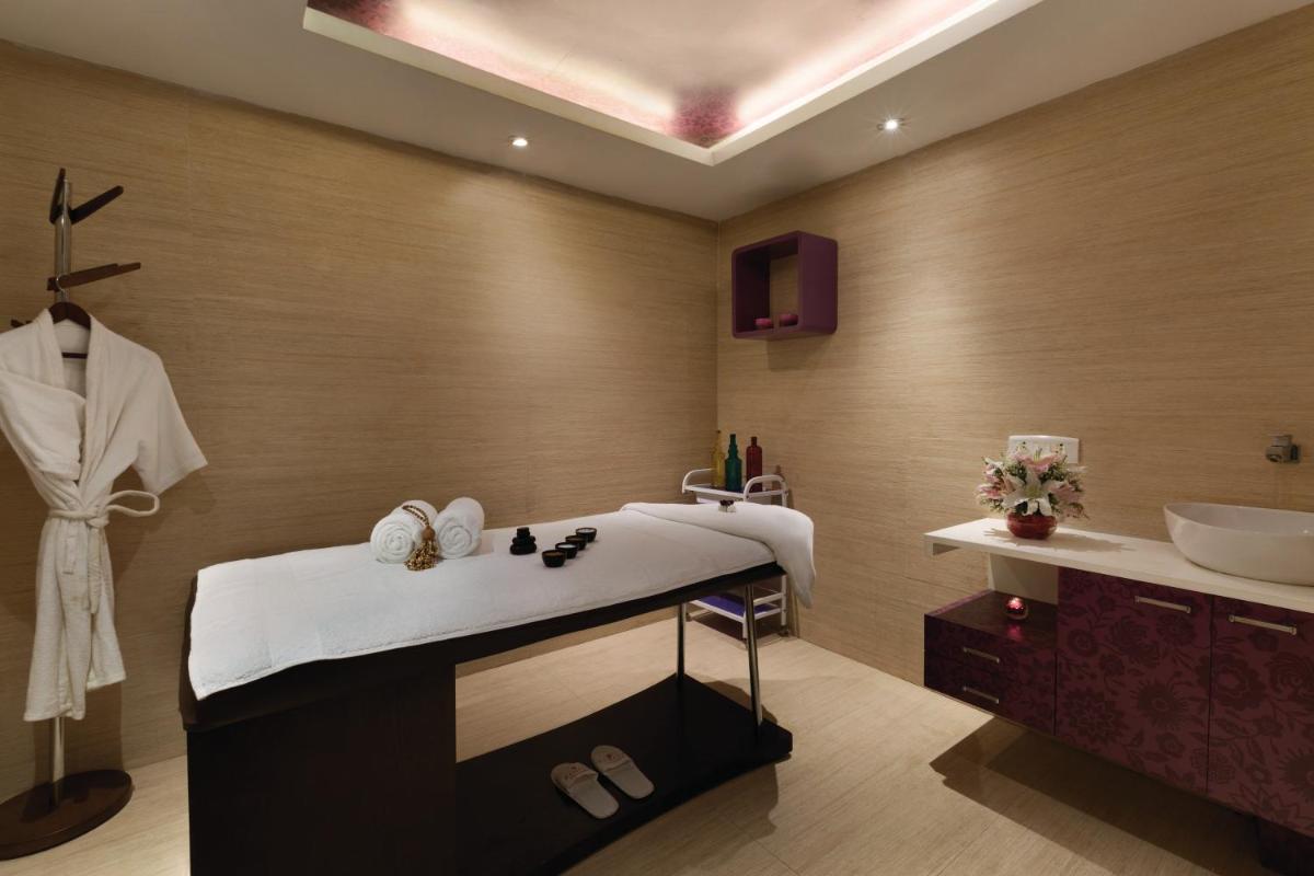a bathroom with a white sink and a tub and a sink at Ramada by Wyndham Chennai Egmore in Chennai a bathroom with a white sink and a tub and a sink at Ramada by Wyndham Chennai Egmore in Chennai