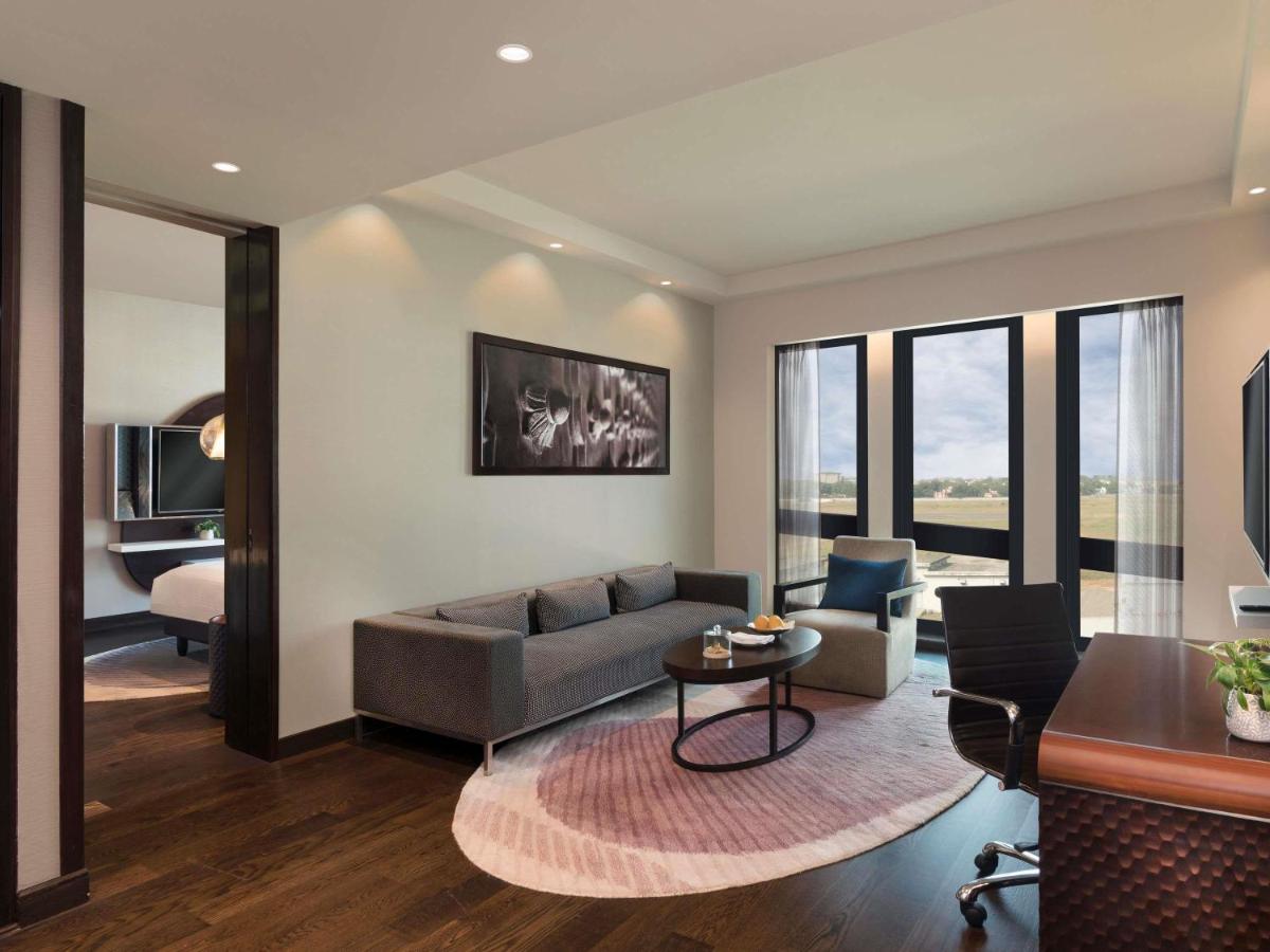a living room with a couch and a table at Pullman New Delhi Aerocity in New Delhi