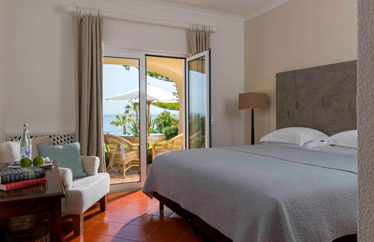 um quarto com uma cama, uma cadeira e uma varanda em Vila Joya em Albufeira mais 112 fotografias