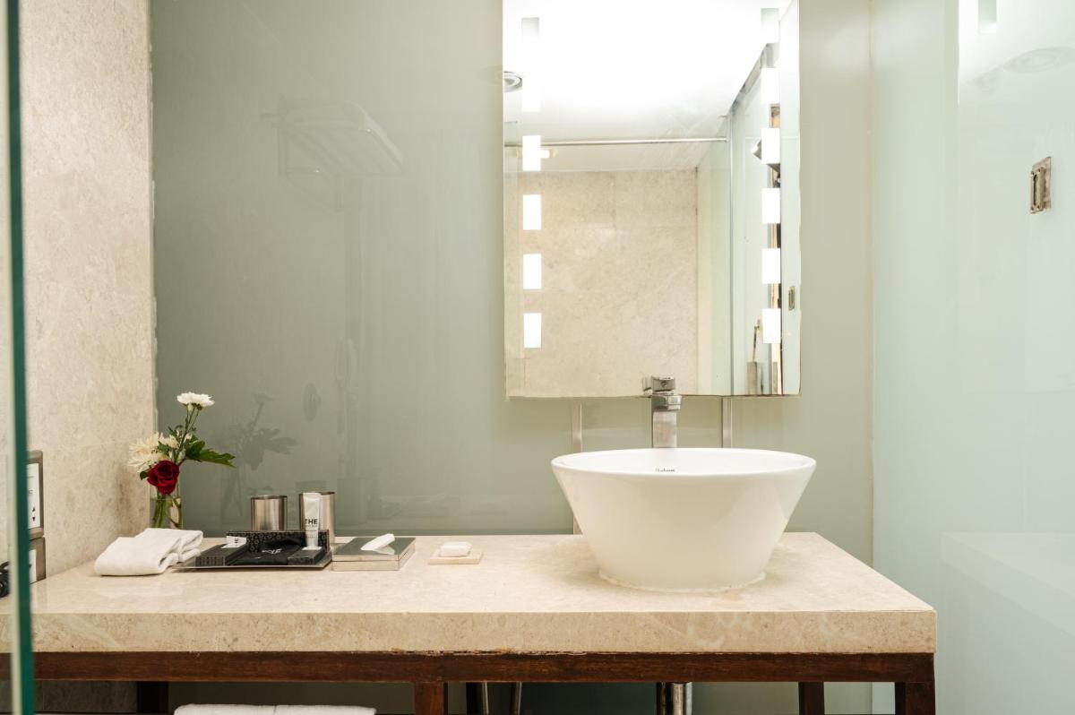 a bathroom with a sink and a mirror at The Park New Delhi in New Delhi a bathroom with a sink and a mirror at The Park New Delhi in New Delhi