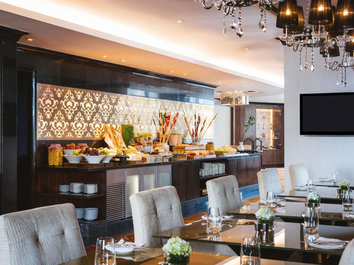a restaurant with tables and chairs and a buffet at Sofitel Mumbai BKC in Mumbai