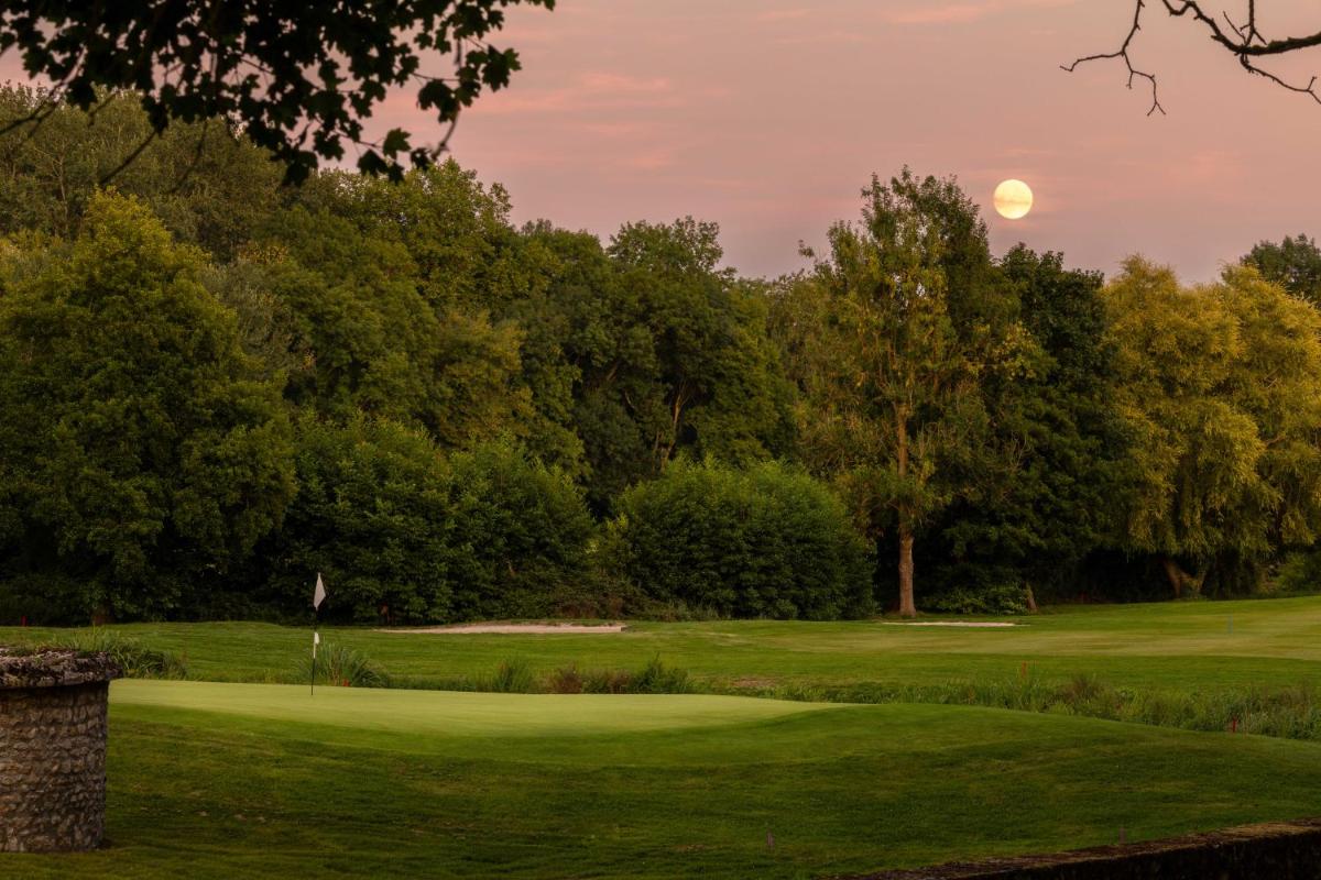 une vue d'un terrain de golf avec la lune dans le ciel dans l'établissement Château d'Augerville Golf & Spa Resort - TemptingPlaces Collection, à Augerville-la-Rivière