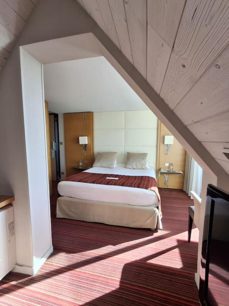 Un ou plusieurs lits dans un hébergement de l'établissement Le Churchill Hôtel & Spa