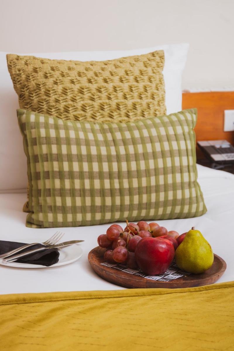 a plate of fruit on a bed with a pillow at The Park New Delhi in New Delhi