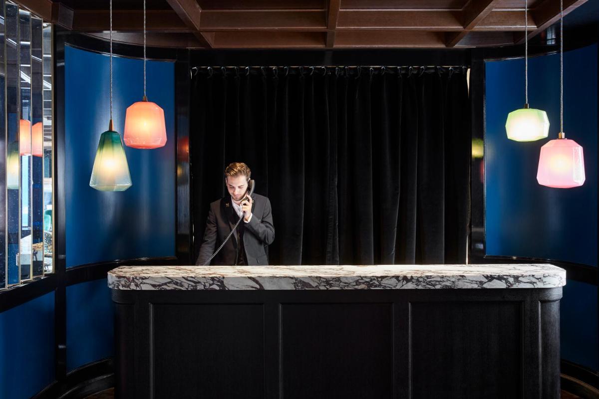 un homme debout derrière un bar avec un microphone dans l'établissement Le Roch Hotel & Spa, à Paris 79 autres photos