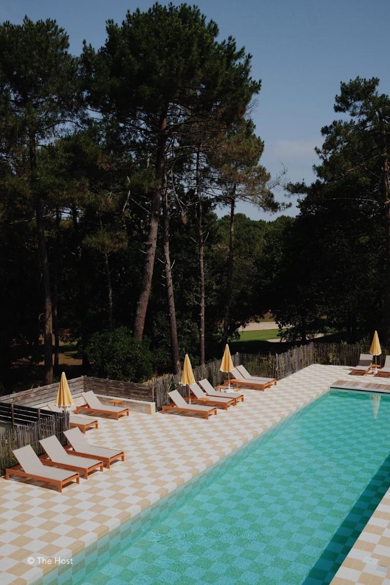 un groupe de chaises longues et une piscine dans l'établissement Boutique Hôtel La Baignoire, à Lacanau-Océan