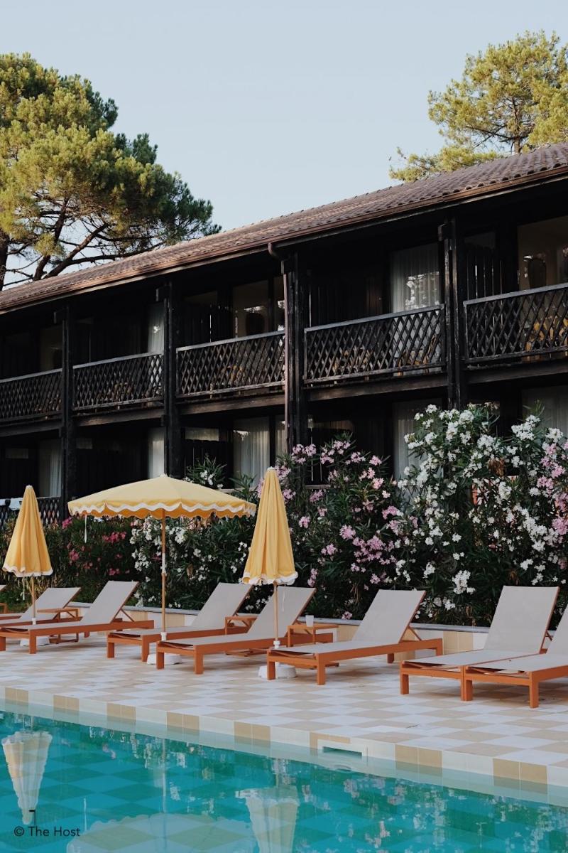 un groupe de chaises longues et de parasols à côté d'une piscine dans l'établissement Boutique Hôtel La Baignoire, à Lacanau-Océan