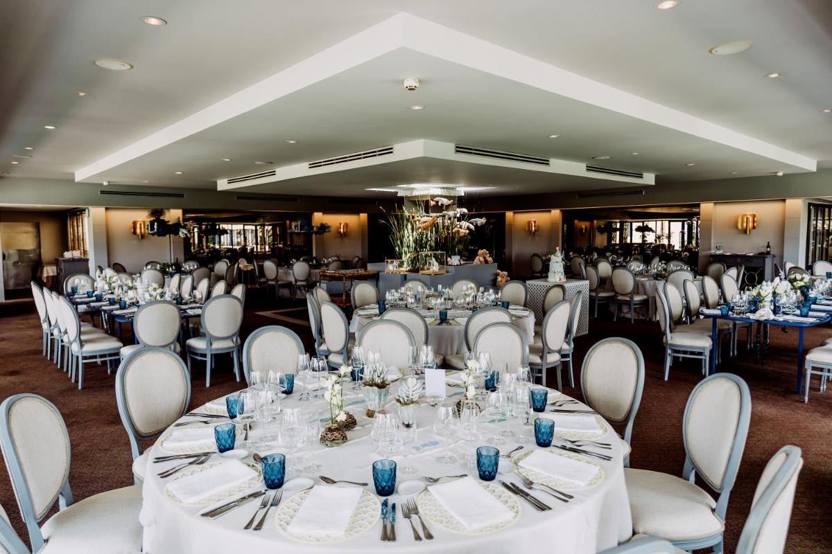 um salão de banquetes com mesas e cadeiras brancas em Hotel Solverde Spa and Wellness Center em Vila Nova de Gaia