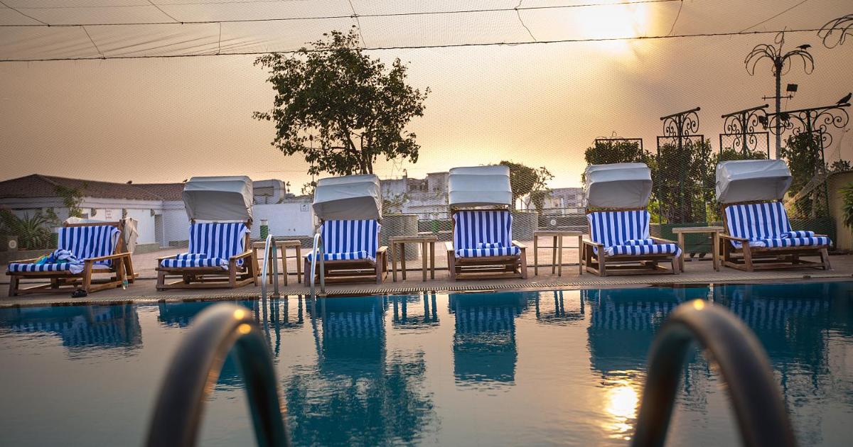 a group of chairs sitting next to a swimming pool at The Orchid Hotel Mumbai Vile Parle in Mumbai