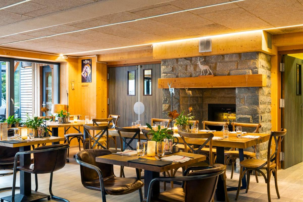 un restaurant avec des tables et des chaises et une cheminée dans l'établissement Domaine du Hirtz, Restaurant & Spa, à Wattwiller
