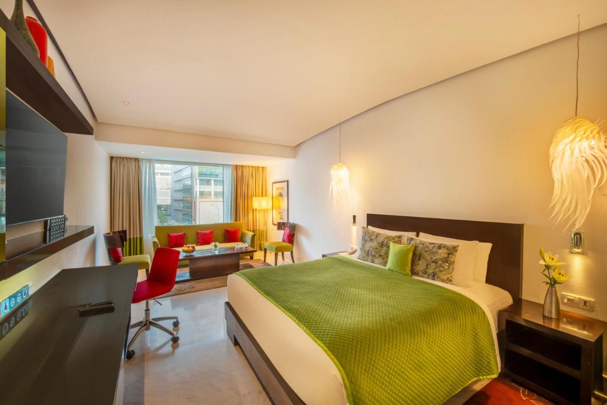 a hotel room with a bed and a desk and chairs at The Park Chennai in Chennai