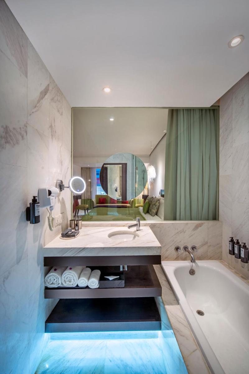 a bathroom with a tub and a sink and a mirror at The Park Chennai in Chennai
