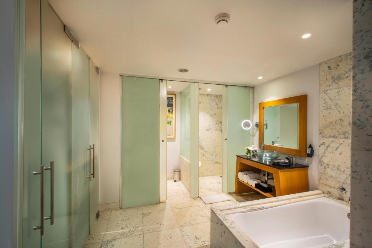 a bathroom with a tub and a sink and a mirror at The Park Chennai in Chennai