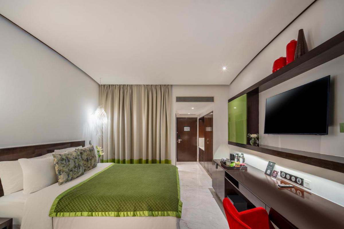 a hotel room with a bed and a flat screen tv at The Park Chennai in Chennai