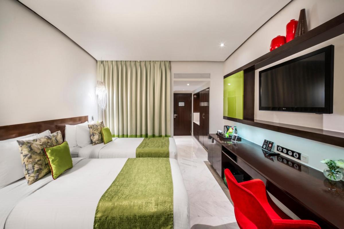 a hotel room with two beds and a flat screen tv at The Park Chennai in Chennai